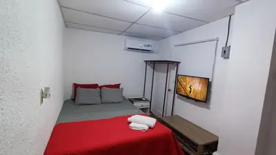 a small room with a bed with a red blanket at Studio Suite 3, Buena Vista, Santa Tecla in Nueva San Salvador