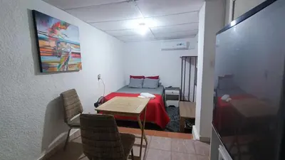 a room with a bed and a table and chairs at Studio Suite 3, Buena Vista, Santa Tecla in Nueva San Salvador