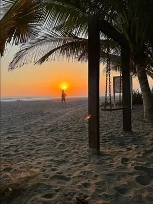 a person standing on a beach with the sunset in the background at DONDE ANTONIO BARRA DE SANTIAGO in Barra de Santiago