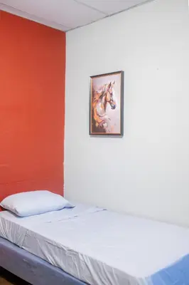 a bed in a room with a painting on the wall at Bambu Hostel in Juayúa