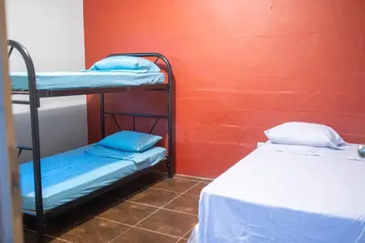 two bunk beds in a room with a red wall at Bambu Hostel in Juayúa