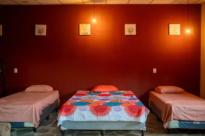 two beds in a room with red walls at Bambu Hostel in Juayúa