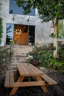 a wooden picnic table in front of a building at Bambu Hostel in Juayúa