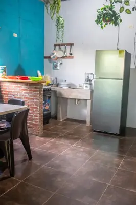 a kitchen with a stainless steel refrigerator and a table at Bambu Hostel in Juayúa