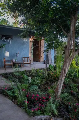 a garden with a bench and flowers in front of a house at Bambu Hostel in Juayúa