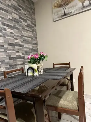 a dining room table with flowers on top of it at Placentero y acogedor apartamento en Calle Monserrat in San Salvador