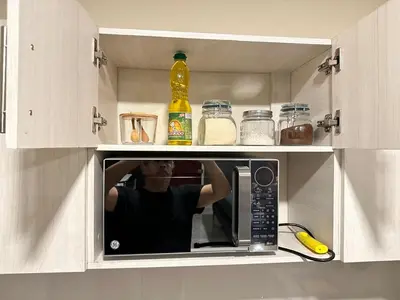 a man taking a picture in a microwave in a kitchen at Placentero y acogedor apartamento en Calle Monserrat in San Salvador