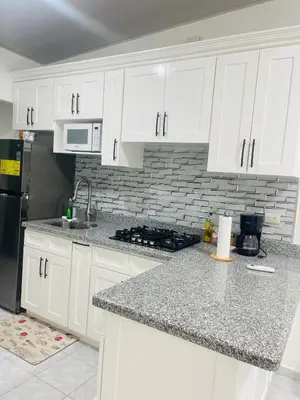 a kitchen with white cabinets and a black refrigerator at Holiday home in San Miguel