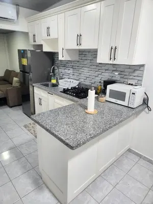 a kitchen with white cabinets and a microwave on a counter at Holiday home in San Miguel