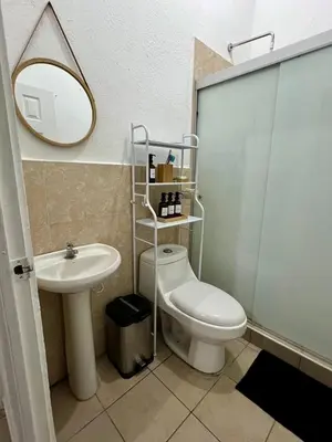 a bathroom with a toilet and a sink and a mirror at Casa Luz - complete with pool access in Sitio del Niño