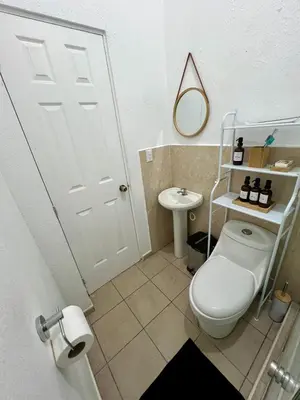 a bathroom with a white toilet and a sink at Casa Luz - complete with pool access in Sitio del Niño