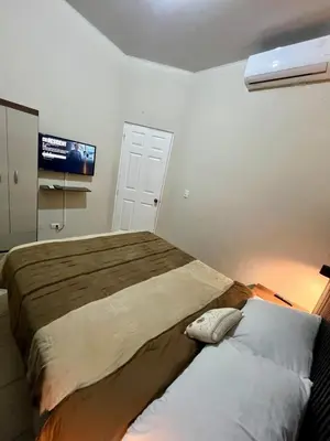 a bedroom with a large bed and a flat screen tv at Casa Luz - complete with pool access in Sitio del Niño