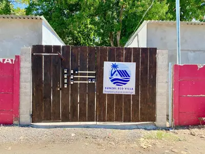 a wooden gate with a sign on it next to two red doors at Eco Villa, El Sunzal ISA Surfing in El Sunzal
