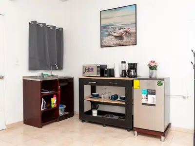 a kitchen with a counter and a refrigerator and a table at Eco Villa, El Sunzal ISA Surfing in El Sunzal