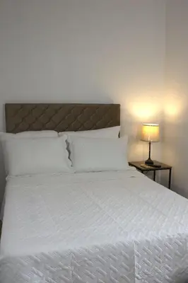 a bedroom with a white bed with a headboard and a lamp at Eco Villa, El Sunzal ISA Surfing in El Sunzal