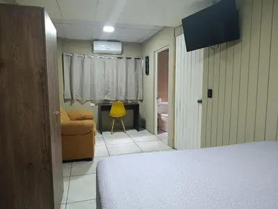 a bedroom with a bed and a couch in a room at Kartagus B&B in San Salvador