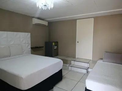 a bedroom with two beds and a chandelier at Kartagus B&B in San Salvador
