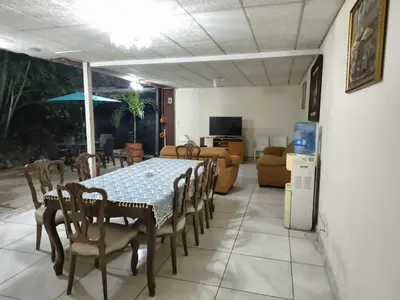 a dining room and living room with a table and chairs at Kartagus B&B in San Salvador