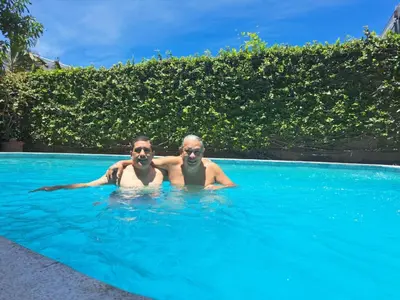 two men are laying in a swimming pool at Kartagus B&B in San Salvador