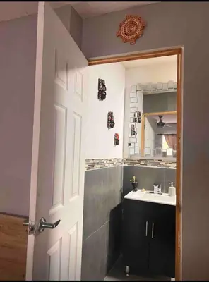 a bathroom with a sink and a door with a mirror at Smart and Modern Room Full Amenities in San Salvador in San Salvador