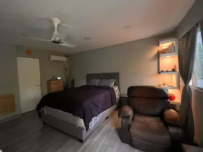a bedroom with a bed and a chair at Smart and Modern Room Full Amenities in San Salvador in San Salvador
