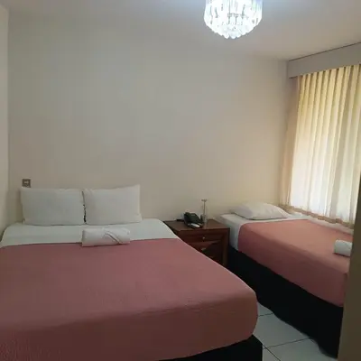 a bedroom with two beds and a chandelier at Kartagus Centric in San Salvador