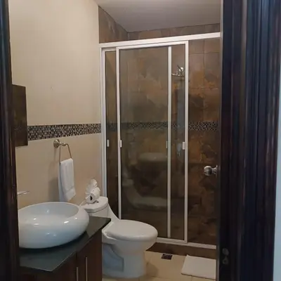 a bathroom with a shower and a toilet and a sink at Kartagus Centric in San Salvador