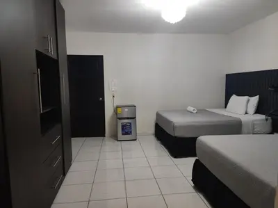 a hotel room with two beds and a trash can at Kartagus Centric in San Salvador