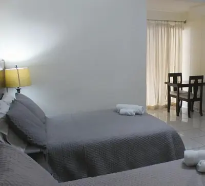 a bedroom with a bed and a table and chairs at Kartagus Centric in San Salvador