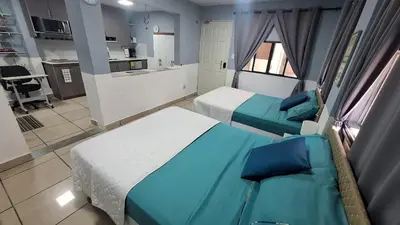 a room with two beds and a kitchen in it at Pearl of the sea in La Libertad
