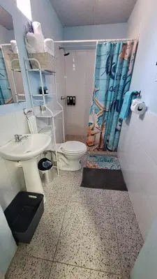 a bathroom with a toilet and a sink and a shower at Pearl of the sea in La Libertad