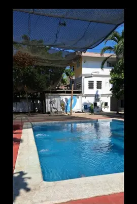 a swimming pool with blue water in front of a house at Pearl of the sea in La Libertad