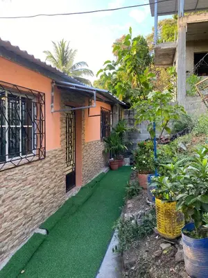 a house with a green lawn in front of it at Aguiñada's House in El Rosario