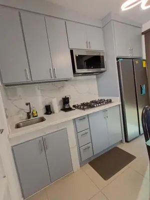 a kitchen with white cabinets and a sink and a microwave at Nueva San Miguel Miami 703 in San Miguel