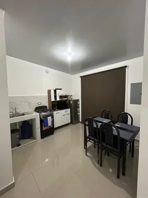 a dining room with a table and chairs and a kitchen at Nueva San Miguel Miami 703 in San Miguel