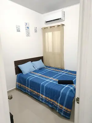 a bedroom with a bed with blue sheets and a window at Casa de Reyes in San Miguel