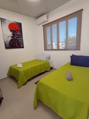 a room with two green beds and a window at Residencial Nueva San Miguel Miami 703 in San Miguel