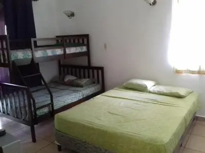 a bedroom with two bunk beds and a chair at Casa de Playa en residencial las Veraneras San Fer in Los Cóbanos