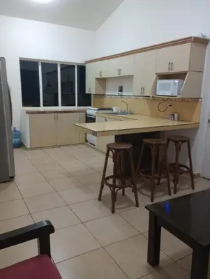 a kitchen with a counter and some stools in it at Casa de Playa en residencial las Veraneras San Fer in Los Cóbanos