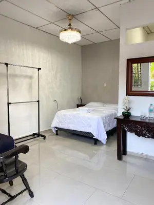 a bedroom with a bed and a table and a chair at Apartamento Moderno y Privado in Santa Ana