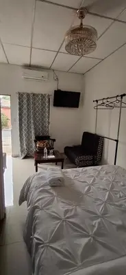 a bedroom with a bed and a couch and a chandelier at Apartamento Moderno y Privado in Santa Ana