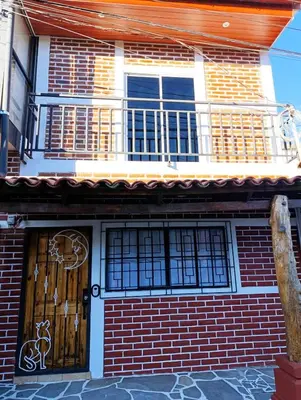 a house with a balcony and a wooden door at Dinos House in Concepción de Ataco