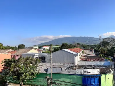 a city with buildings and a mountain in the background at Ipan Noya in Nueva San Salvador