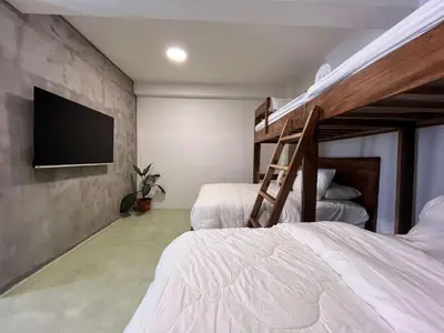 a bedroom with two bunk beds and a flat screen tv at Ipan Noya in Nueva San Salvador