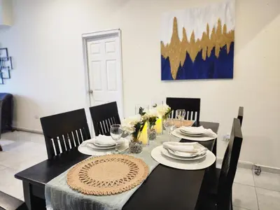 a dining room table with chairs and a black table with plates at Complete, Centrally-located apartment with panoramic view in San Salvador
