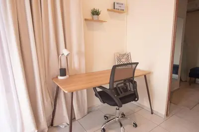 a desk with a chair and a lamp in a room at Complete, Centrally-located apartment with panoramic view in San Salvador