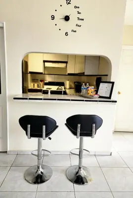 a kitchen with two bar stools in front of a counter at Complete, Centrally-located apartment with panoramic view in San Salvador