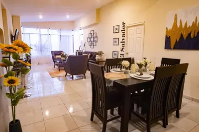 a dining room and living room with a table and chairs at Complete, Centrally-located apartment with panoramic view in San Salvador