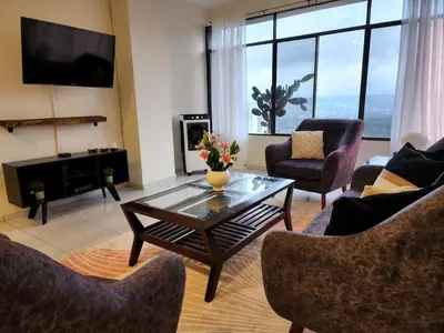 a living room with a coffee table and chairs at Complete, Centrally-located apartment with panoramic view in San Salvador