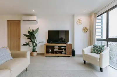 a living room with a tv and a couch and a chair at Cielo 404 in San Salvador